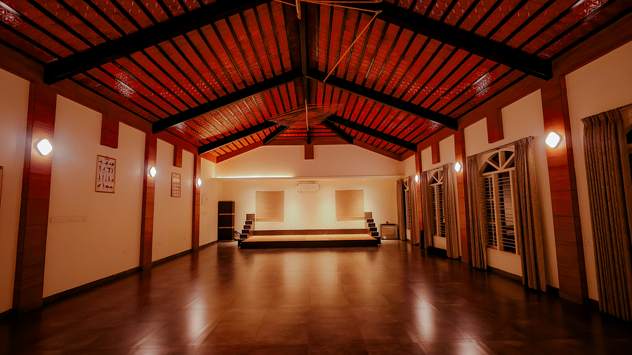 An empty event space or hall with a high ceiling and wooden floor at Nirantara Resort & Spa.