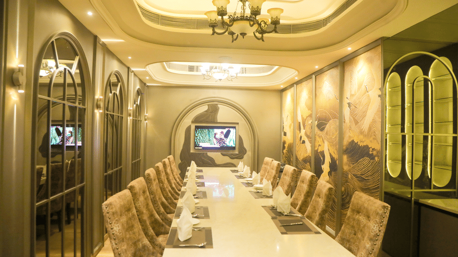 Elegant private dining room with long table, upholstered chairs, and decorative ceiling at Nirvana Gateway.