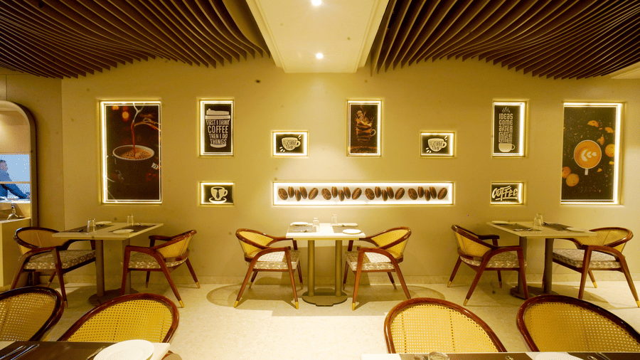 Dining area with round tables, wooden chairs, and framed wall decor at Nirvana Gateway.