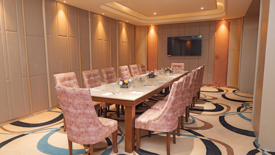 Modern meeting room with long conference table and cushioned chairs at Nirvana Gateway.
