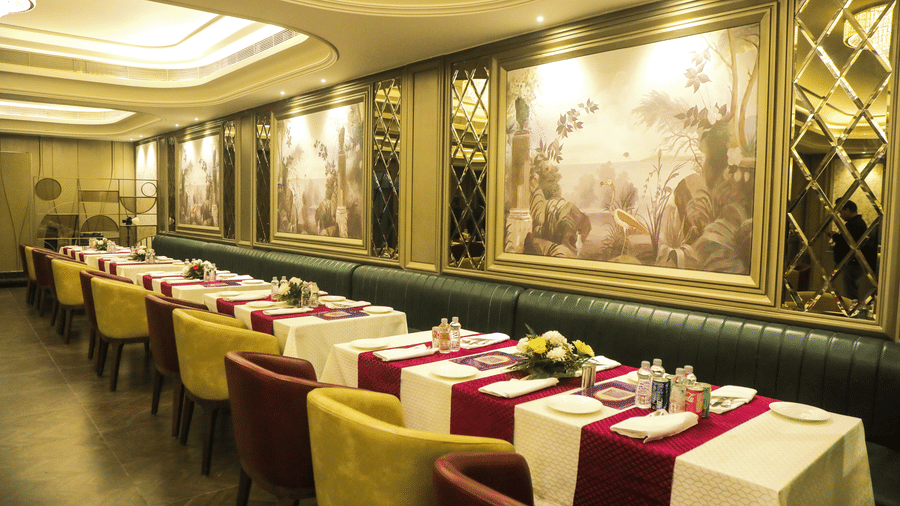 Fine dining restaurant with wall murals, table settings, and cushioned seating at Nirvana Gateway.