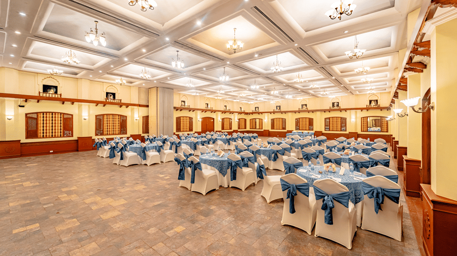 The brightly lit Emperor Hall at Noor-Us-Sabah Palace, Bhopal, showcasing small chandeliers hanging from the ceiling with grey-coloured tile flooring at Noor-Us-Sabah Palace, Bhopal.