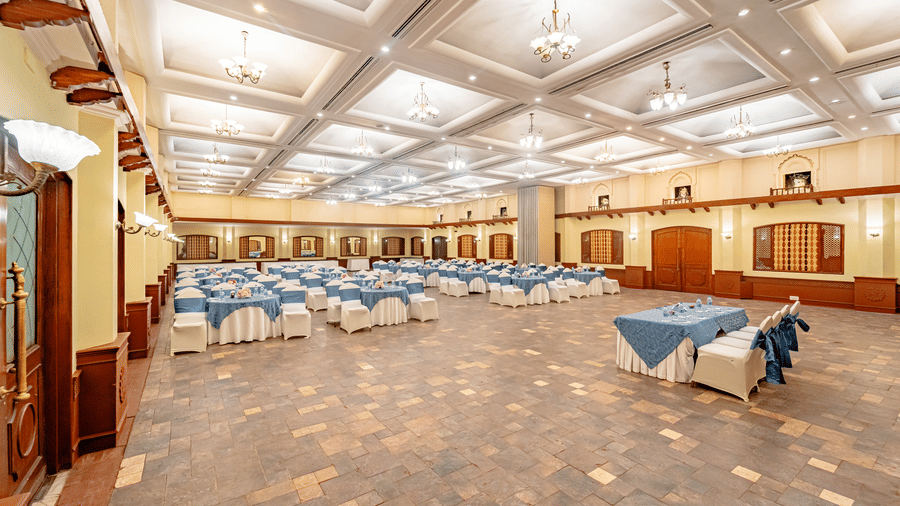 Full view of the spacious Emperor Hall at the Noor-Us-Sabah Palace, Bhopal, featuring tables and chairs arranged for an event.
