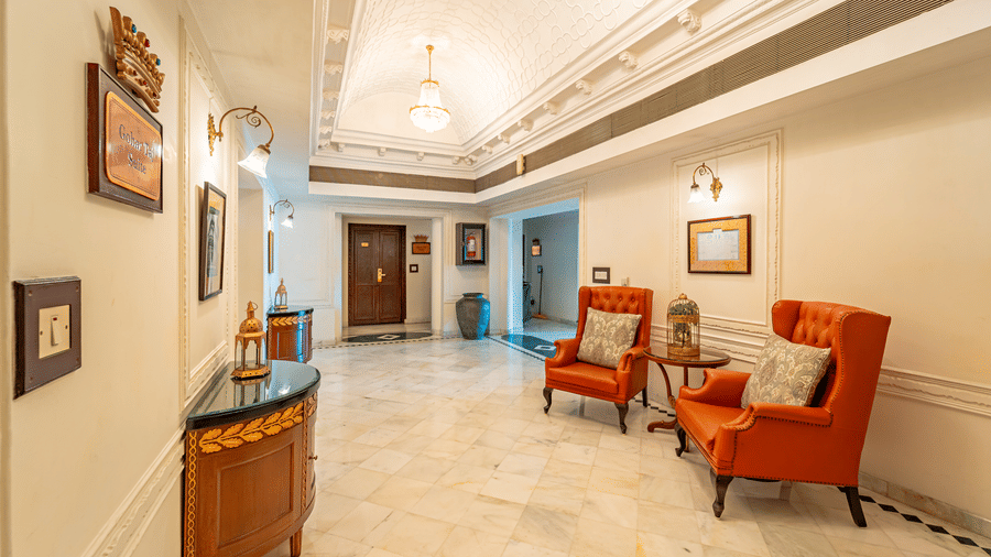 2 crimson arm chairs placed in the lobby with a cushion on each at Noor-Us-Sabah Palace, Bhopal.