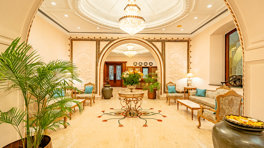 Full view of the lobby area of Noor-Us-Sabah Palace, Bhopal, with a table in the centre of it showcasing a flower vase right below the beautiful chandelier.