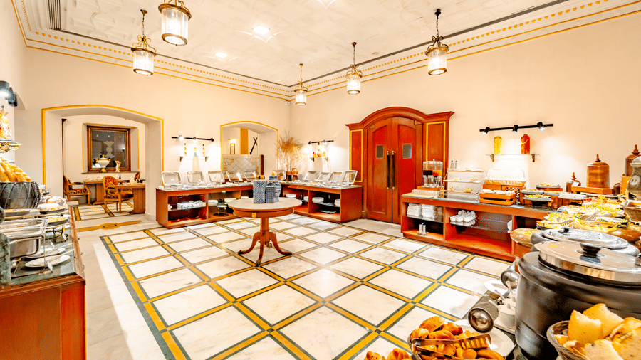 Interior view of the buffet hall at Marble Arch, found at Noor-Us-Sabah Palace, Bhopal, featuring high ceilings, marble floors and wooden counters.