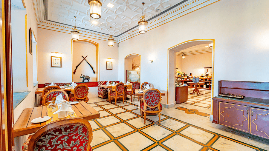 Heritage interiors of the Marble Arch restaurant featuring elegant tile flooring along with the wooden dining tables and chairs at Noor-Us-Sabah Palace, Bhopal.