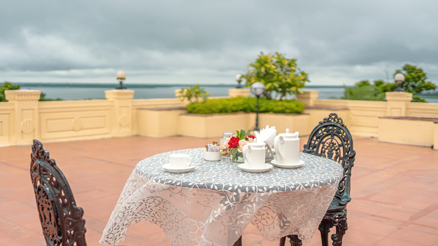 Private terrace of the Presidential Suite at Noor-Us-Sabah Palace, featuring a tea set for 2 overlooking the lake.