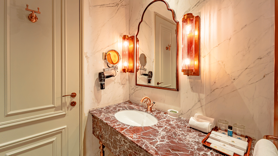 The bathroom of the Royal Club Room with an elegant marble countertop with premium toiletries at Noor-Us-Sabah Palace, Bhopal.