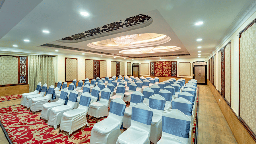 Full view of the Viceroy banquet hall at Noor-Us-Sabah Palace, Bhopal, with an empty space to walk right besides the perimeter of the carpeted area in the hall.