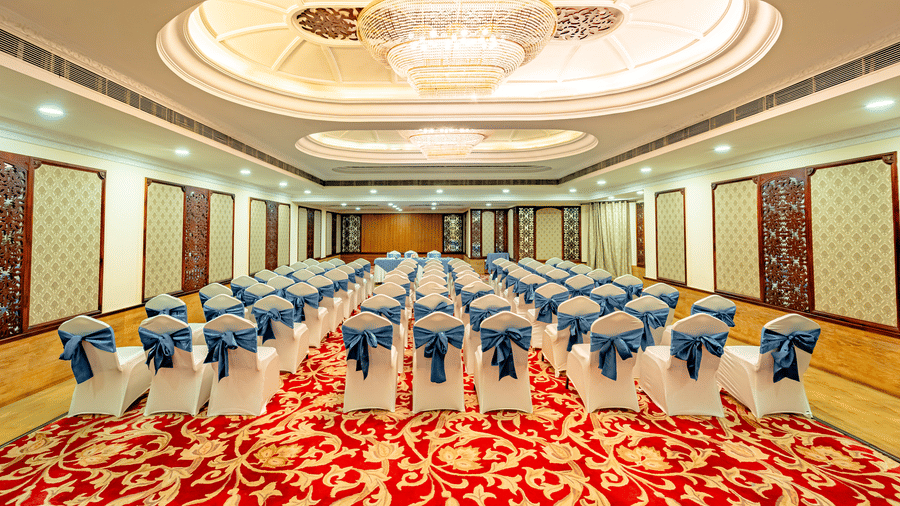 Centre-view shot from the back of the Viceroy banquet hall with a hollow false ceiling at the top, highlight the theatre setting configuration of the chairs at Noor-Us-Sabah Palace, Bhopal.