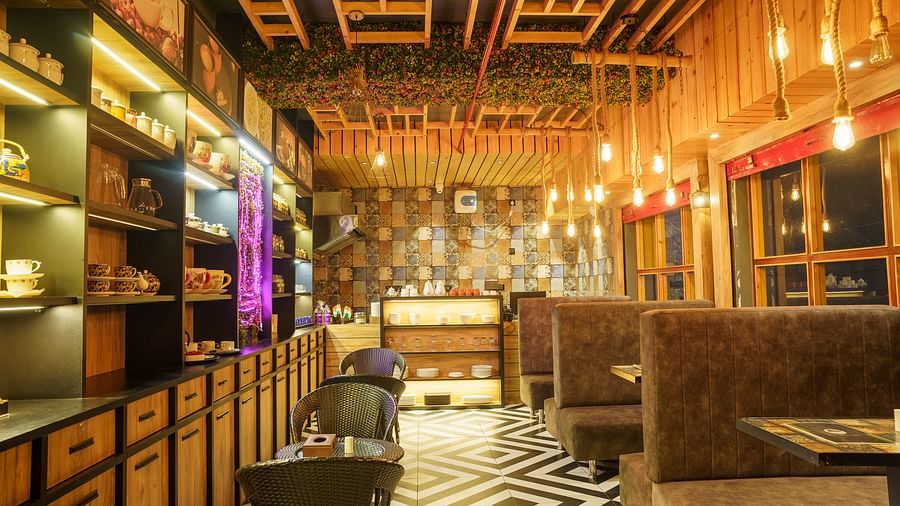 A restaurant with wooden panelled walls and ceiling, dark seating, and decorative hanging lights at Orsino Spa Resort.