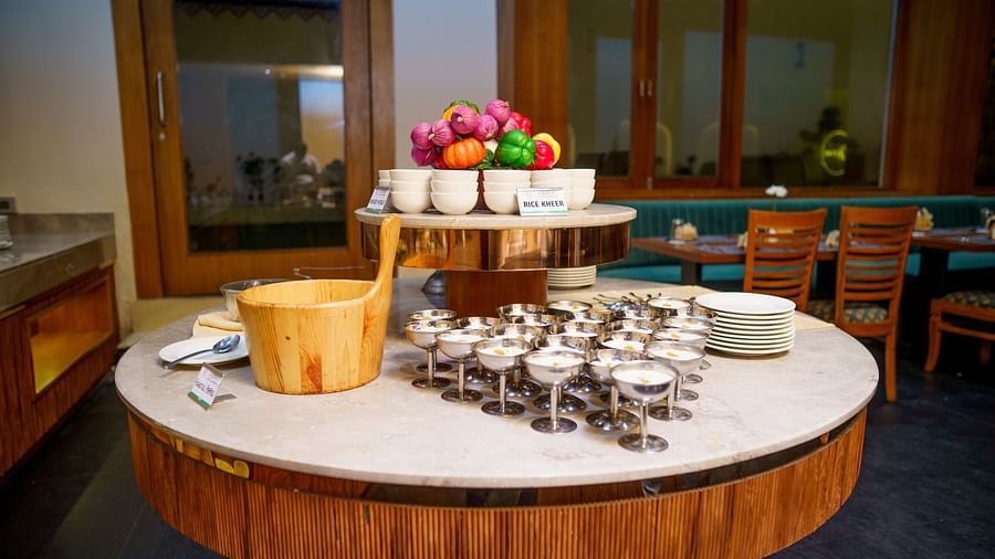 A circular table laden with a tiered fruit display and small pastries, set in a dining area at Orsino Spa Resort.