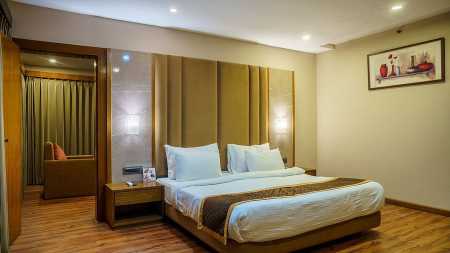 A room at Orsino Spa Resort with a bed featuring a light-coloured headboard, a bedside table, and wooden accents.