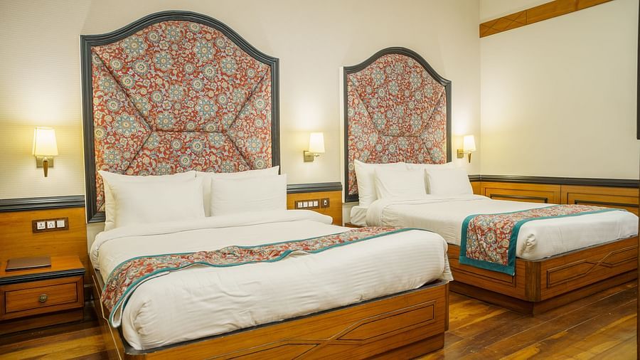 A room at Orsino Spa Resort with two beds, each with a distinctive patterned headboard and a colourful throw.