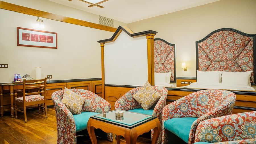 A seating area at Orsino Spa Resort with several armchairs and a sofa, all with patterned upholstery, and wooden wall panelling.