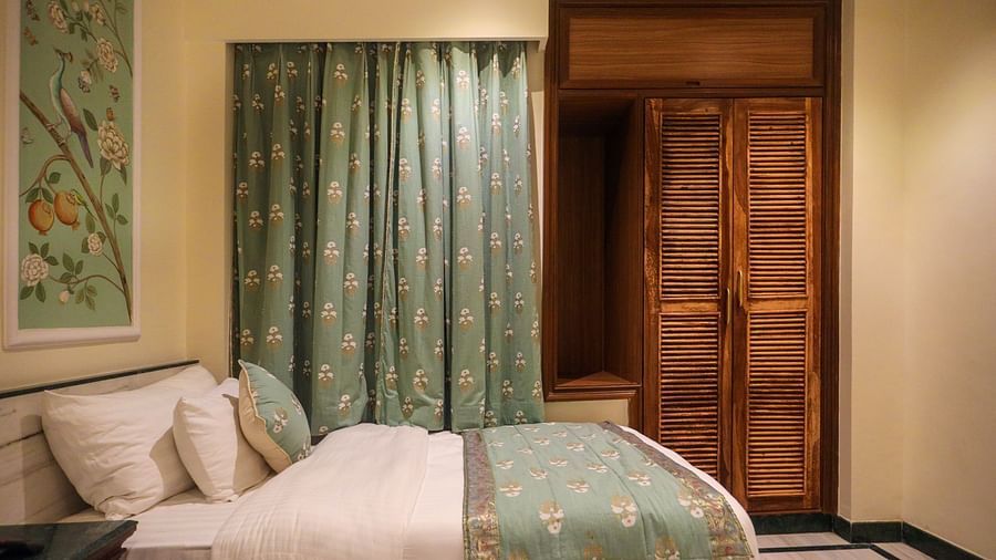 Side view of the Deluxe Twin Room featuring wooden storage and a spacious bed | Panna Vilas Udaipur