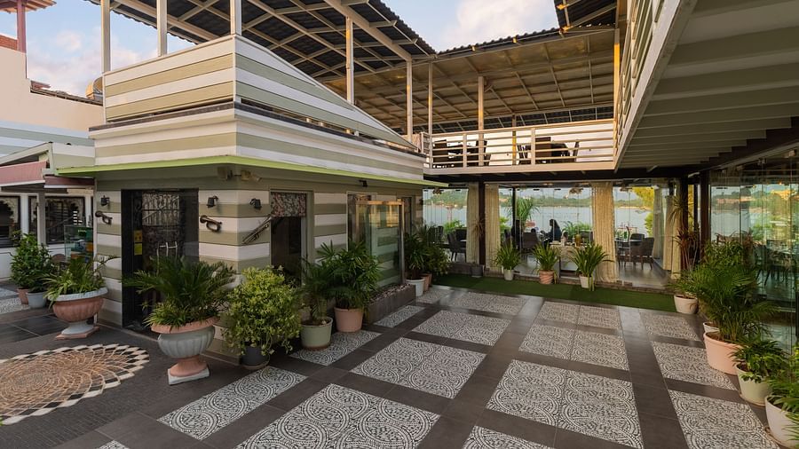 Rooftop restaurant entrance of Panna Vilas Palce features potted plants for decoration, with glass panels separating the dining area.