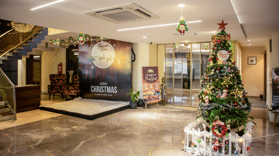 Hotel lobby decorated for Christmas with festive lights, tree, and welcome area at Papaya Tree Hotels.