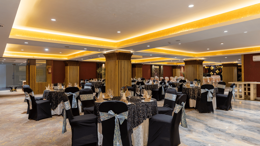Spacious Galaxy Banquet Hall at Papaya Tree Hotels arranged with elegant dining tables and cushioned chairs for formal gatherings.