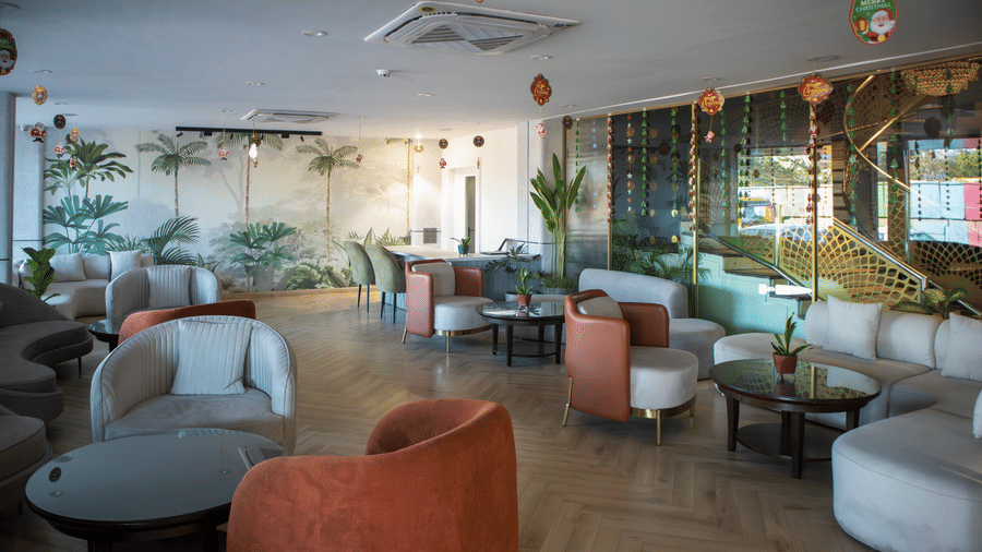 Stylish indoor lounge with comfortable seating, plants, and natural light at Papaya Tree Hotels.