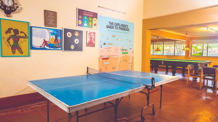 A view of a table tennis table in the game room at Paradise Isle Beach Resort, Udupi with a snooker table visible in the backdrop