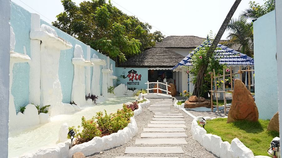 Entrance of a restaurant at Paradise Isle Beach Resort, Udupi with a pastel blue and white theme
