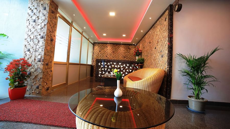 Image of a seating area with ratan furniture and plants at Parampara Residency, Kushalnagar.