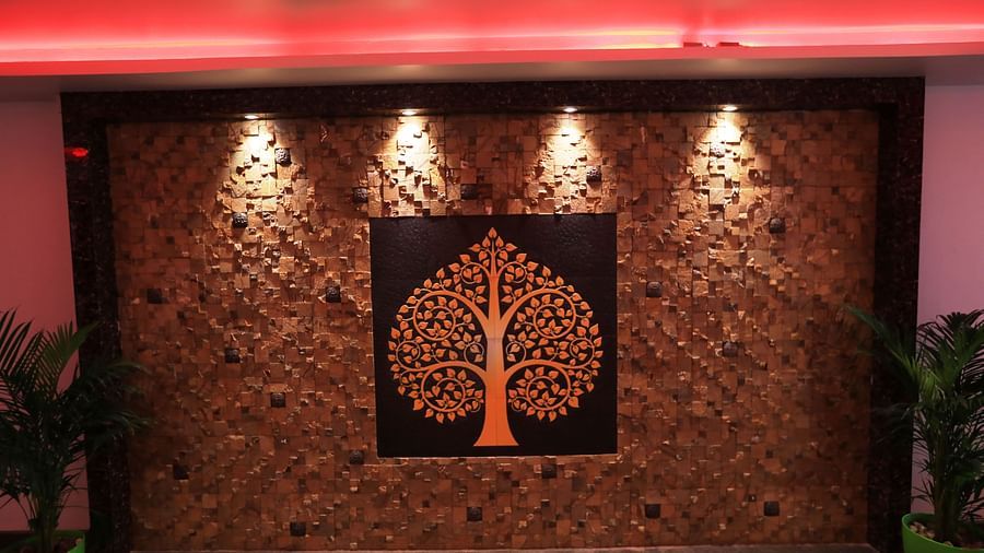 Image of a wall with an engraving and four lights above it at Parampara Residency, Kushalnagar.