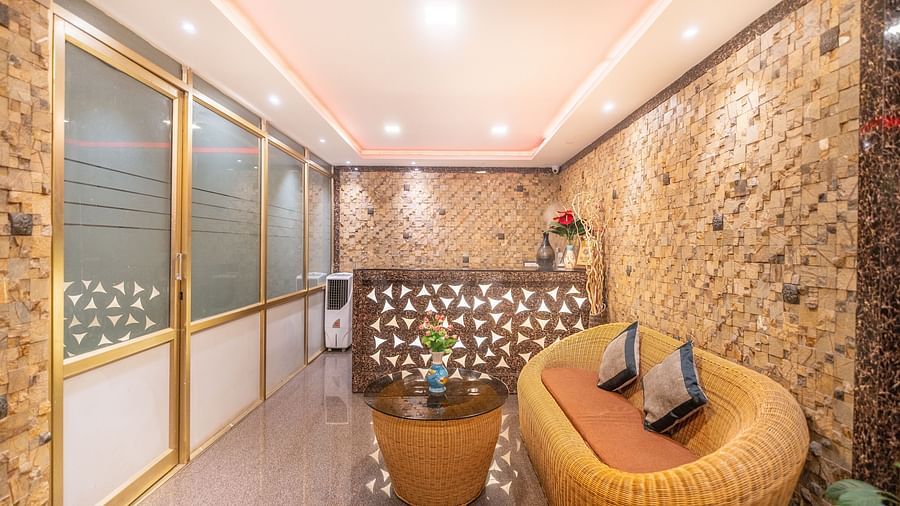 Image of a sitting area with a sofa with a table in front it at Parampara Residency, Kushalnagar.