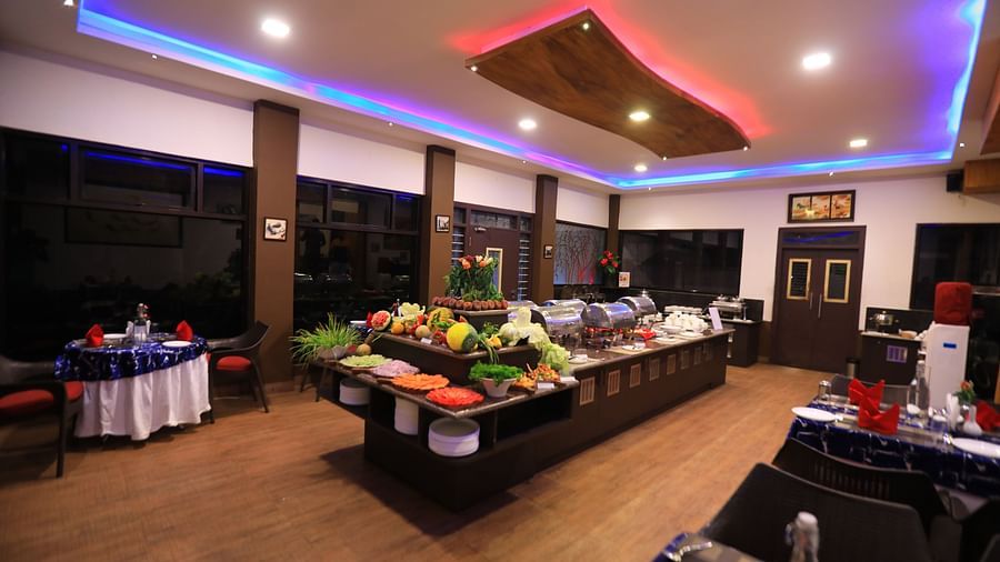 Image of a dining area with buffet table filled with food at Parampara Resort & Spa, Kushalnagar.