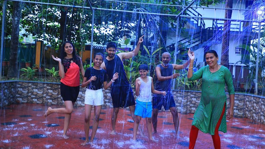 Image of a group of people taking part in a rain dance at Parampara Resort & Spa, Kushalnagar.