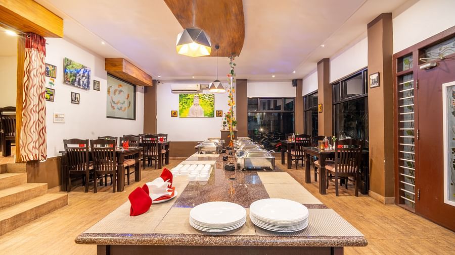 Image of a table with crockery and a light hanging above the table at Parampara Resort & Spa, Kushalnagar.