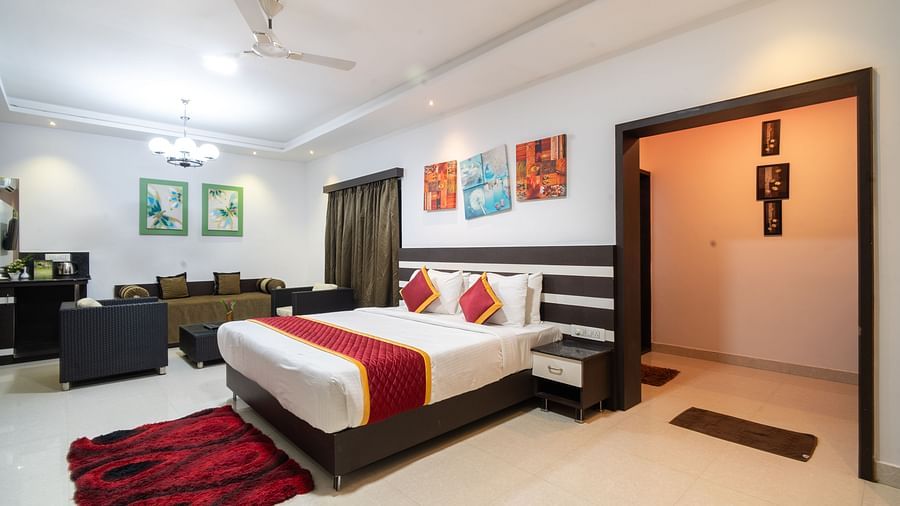 Image of a room with a bed and a wide door beside it at Parampara Resort & Spa, Kushalnagar.