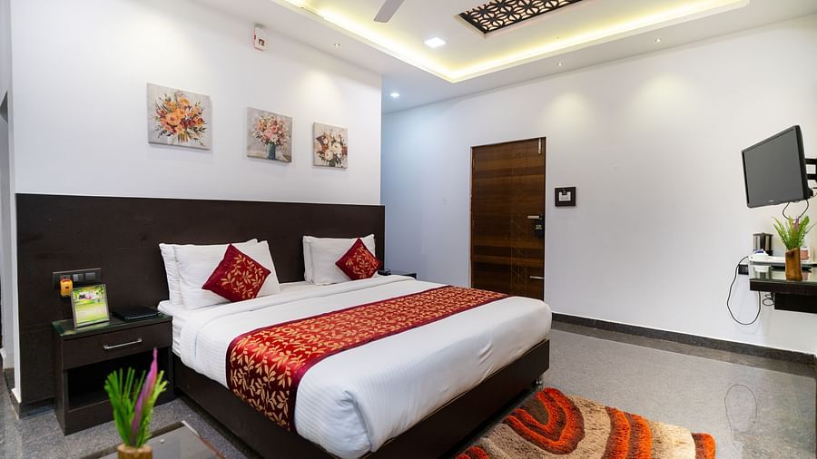 Image of a room with a bed with a rug placed in front of it at Parampara Resort & Spa, Kushalnagar.