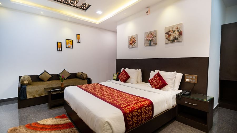 Side view of a room with a bed a sofa on the side at Parampara Resort & Spa, Kushalnagar.