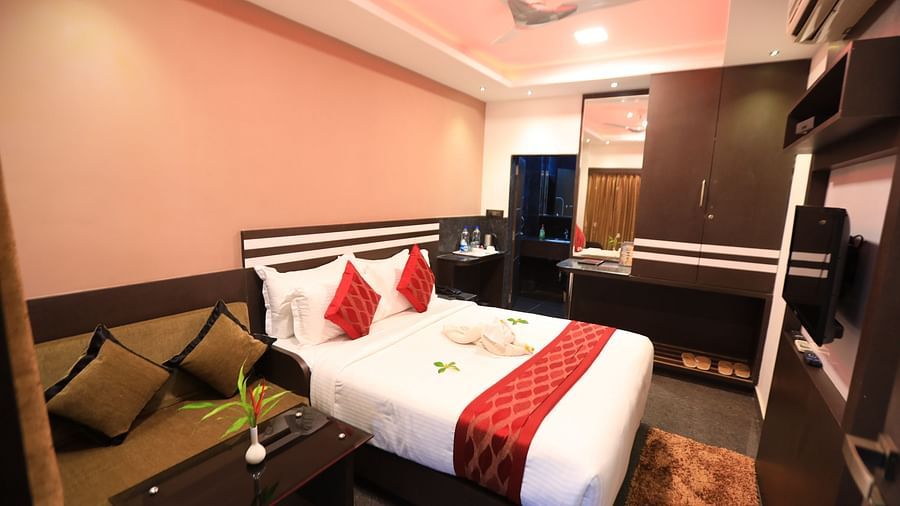 Image of a room with a bed and a table and a sofa beside it at Parampara Resort & Spa, Kushalnagar.