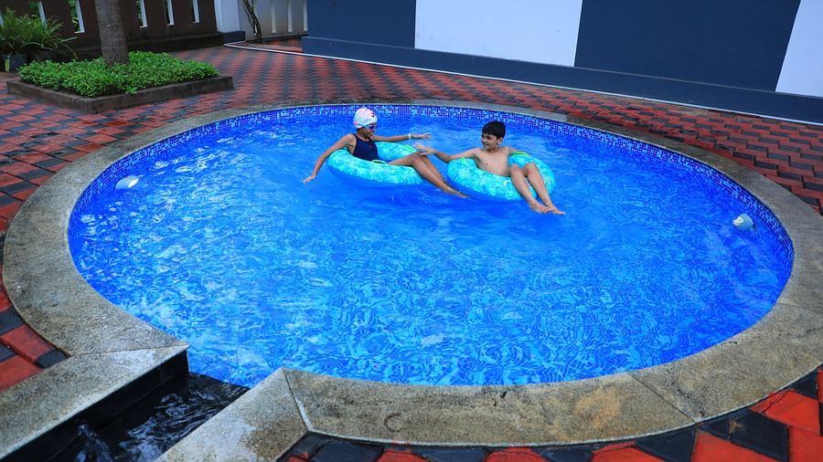 Image of two children sitting on floaties on a swimming pool at Parampara Resort & Spa, Kushalnagar.