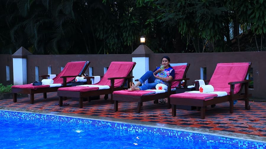 Image of four lounge pools and a woman sitting on one of them at Parampara Resort & Spa, Kushalnagar.