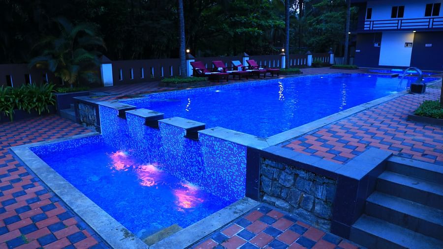 Image of a swimming pool with stairs on the side at Parampara Resort & Spa, Kushalnagar.