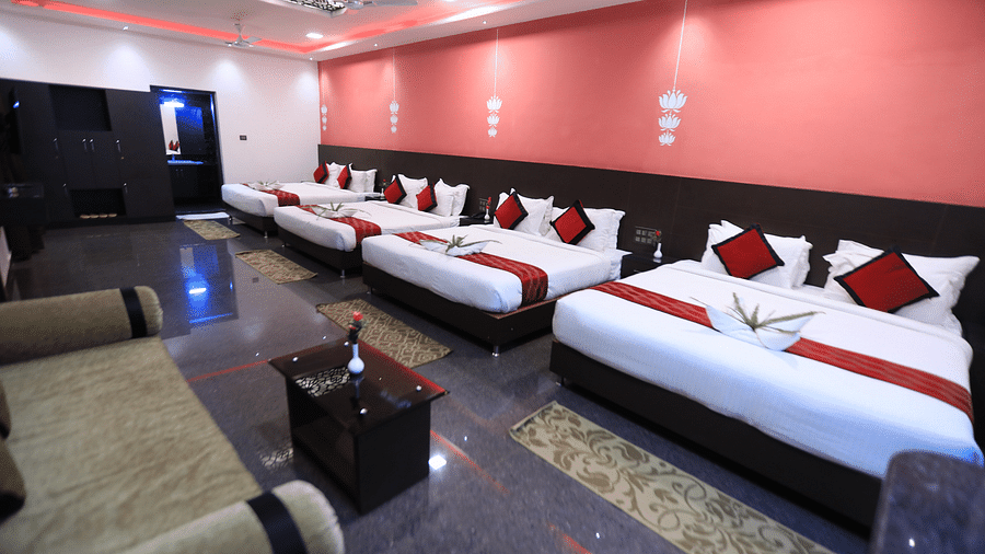 A room with four beds and a sitting area in front at Parampara Resort & Spa, Kushalnagar.