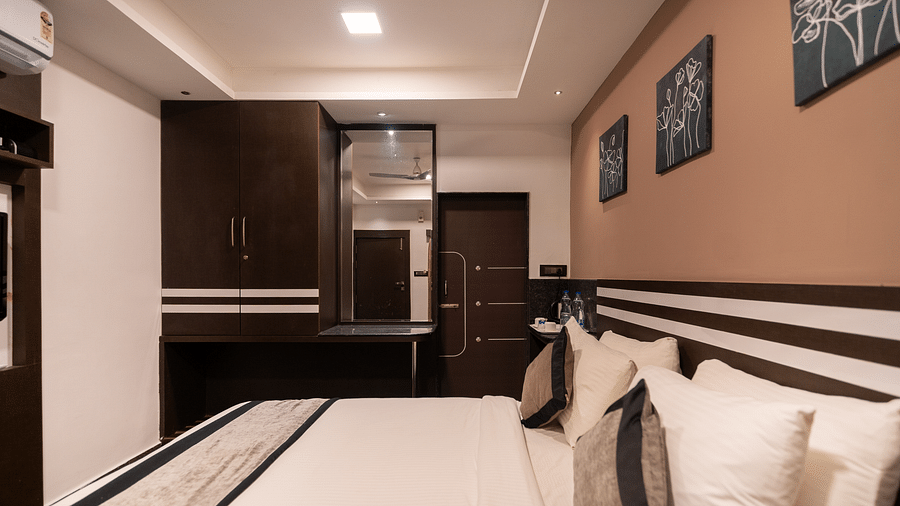 Side view of a room with a bed and a mirror on the side at Parampara Resort & Spa, Kushalnagar.