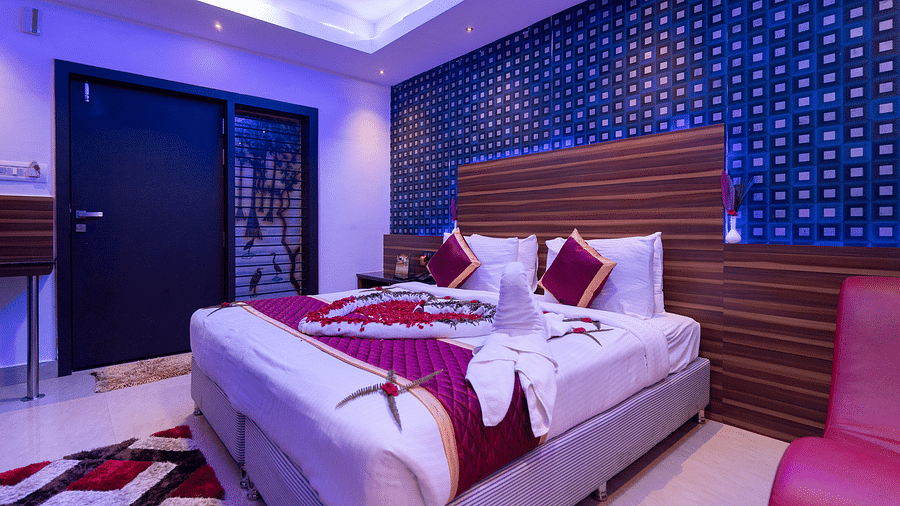A room with a bed decorated with towels and flowers at Parampara Resort & Spa, Kushalnagar.