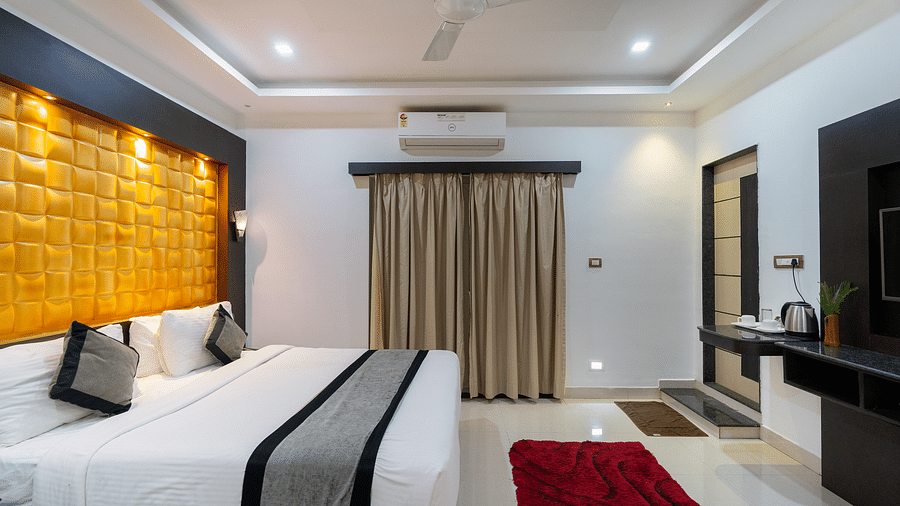 Side view of a room with a bed and a television in front of it at Parampara Resort & Spa, Kushalnagar.