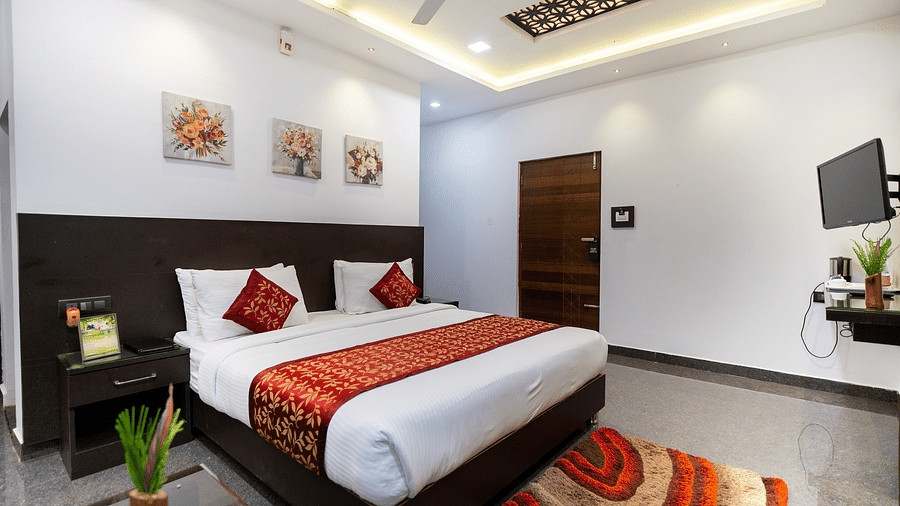 A room with a bed with a rug placed in front of it at Parampara Resort & Spa, Kushalnagar.