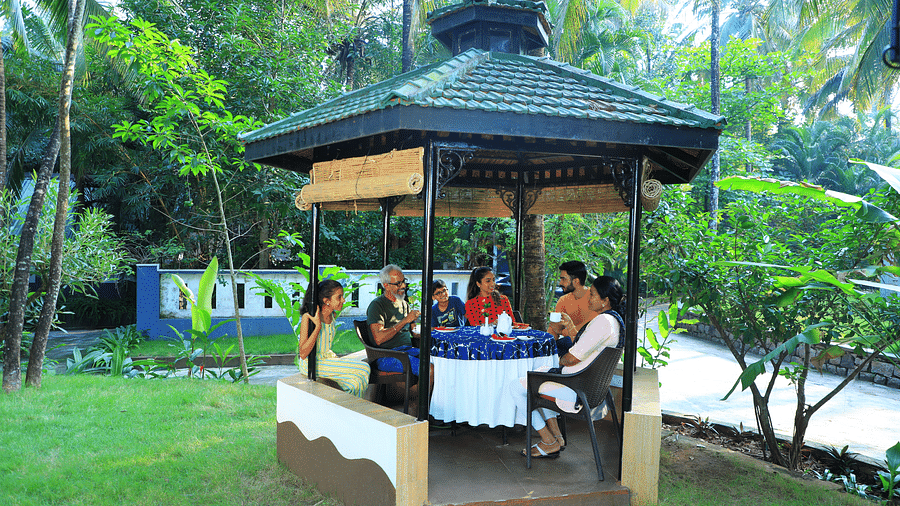A group of people sitting in a gazebo at Parampara Resort & Spa, Kushalnagar.