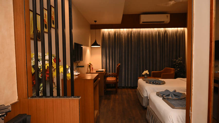 Club Superior Room with a functional work desk and decorative plant divider at Pipul Padmaja Premium Hotel, offering a modern touch.
