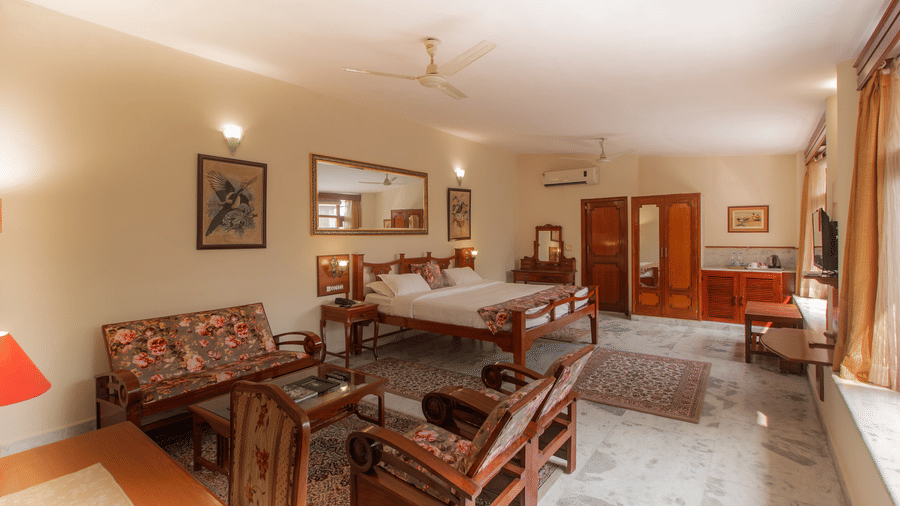 Elegant heritage-style living room with classic wooden furniture, marble flooring, warm lighting, and large windows at Polo Heritage, Managed by Trance.