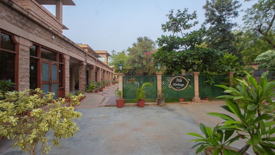 Open courtyard at Polo Heritage, Managed by Trance, Jodhpur featuring heritage architecture, potted plants, and a peaceful garden setting.