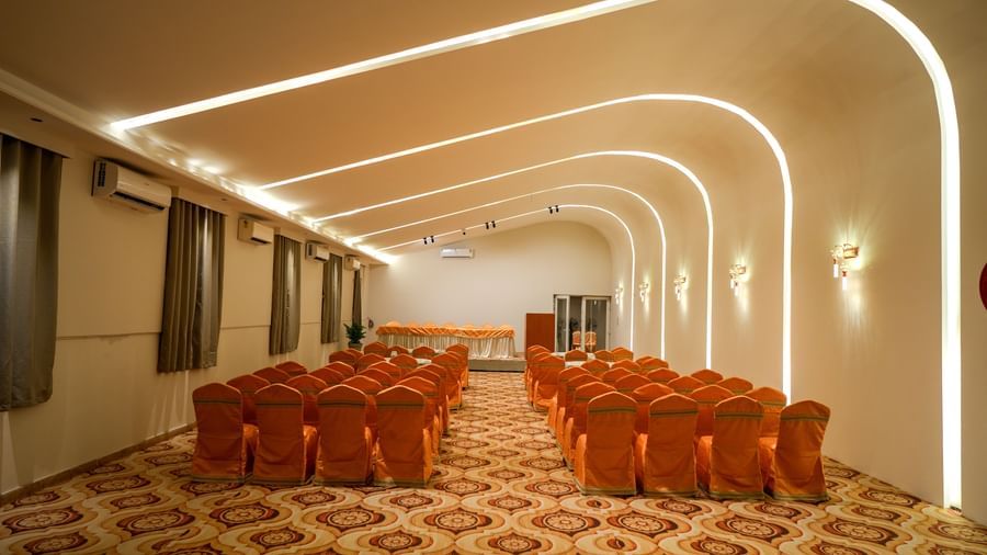 Modern banquet hall with elegant seating and ambient lighting at Pravasa Hotel Kolhapur.
